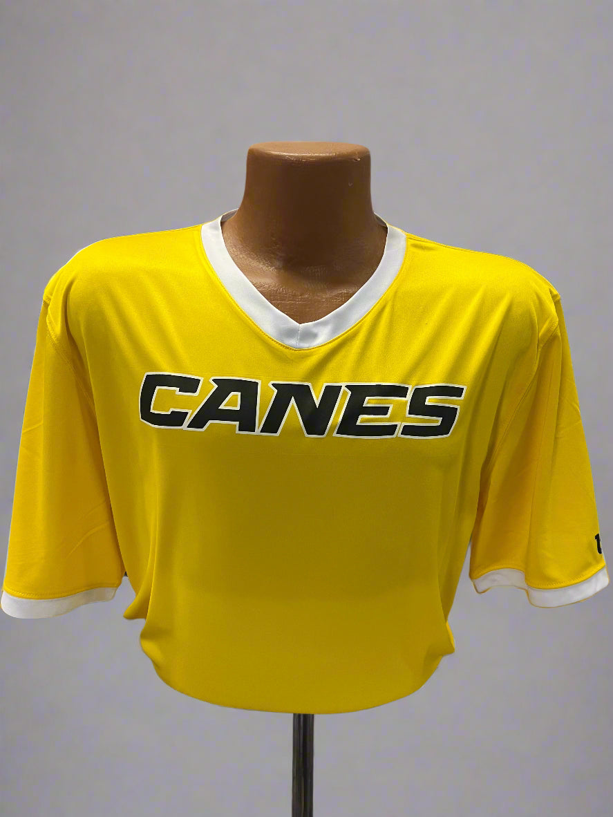 Yellow sports jersey with 'Canes' branding on a mannequin against a display background.