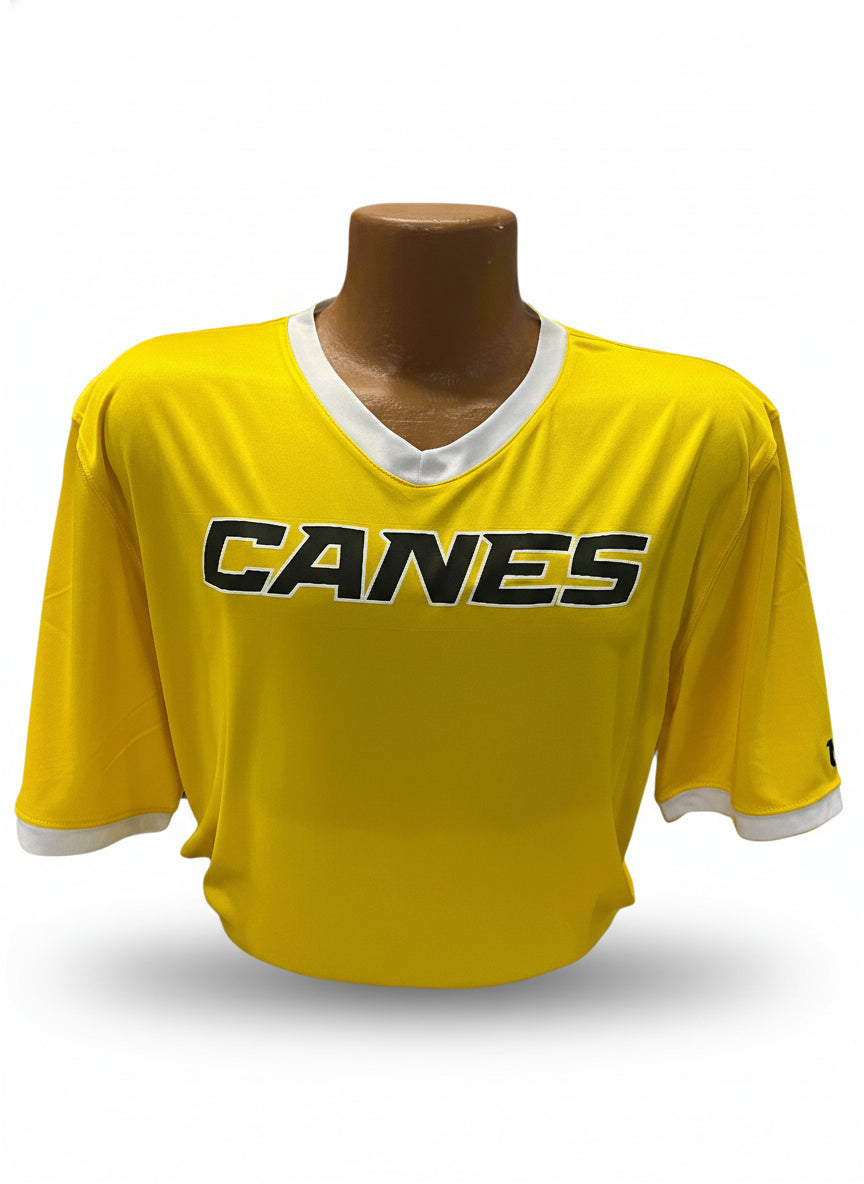 Yellow sports jersey with 'Canes' branding on a mannequin against a display background.